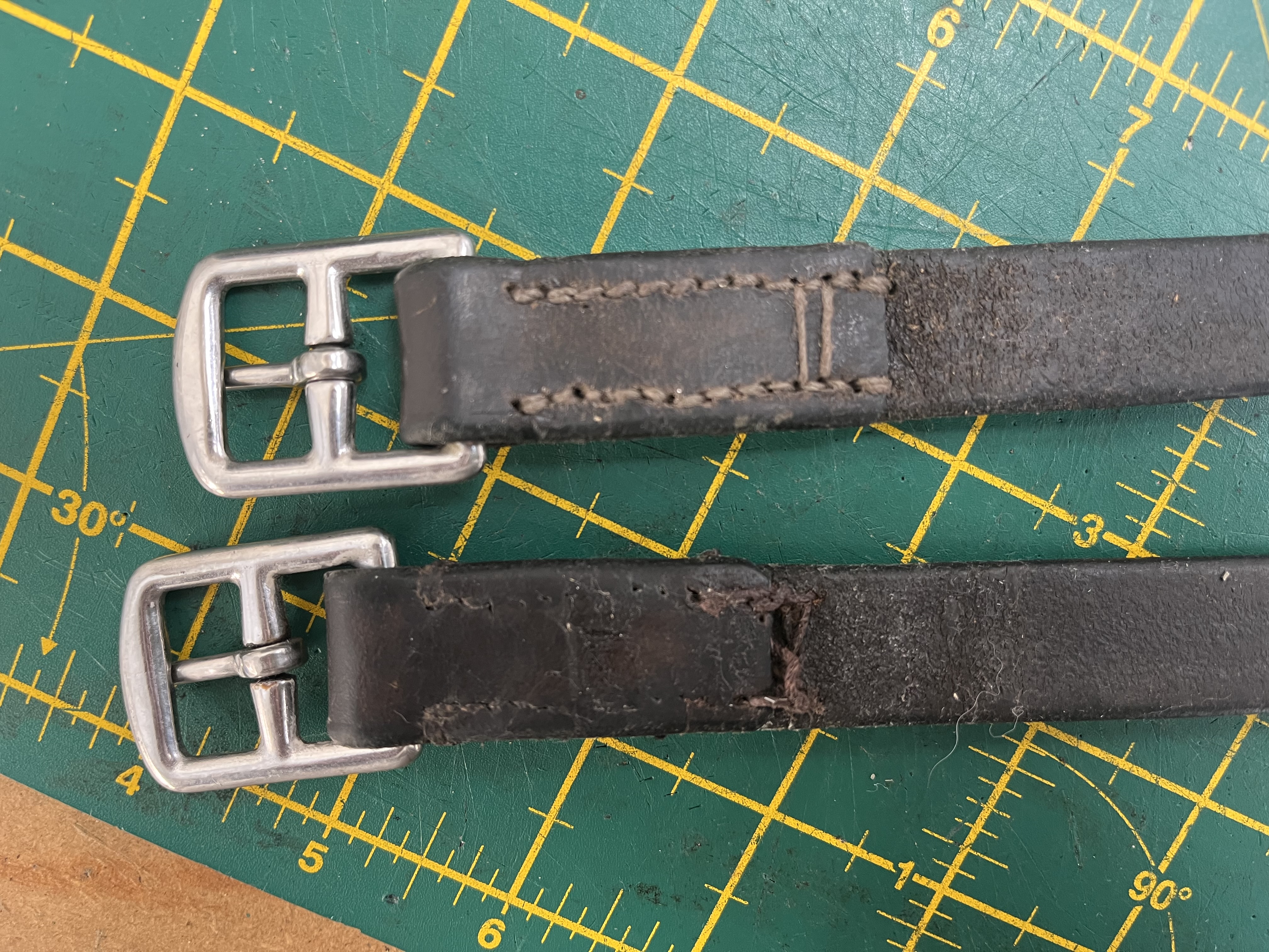 Stirrup leathers before repair — worn stitching and damaged ends